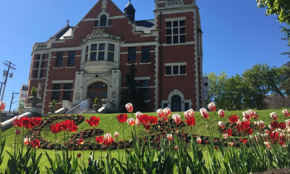 historic red brick building with red and white tulips